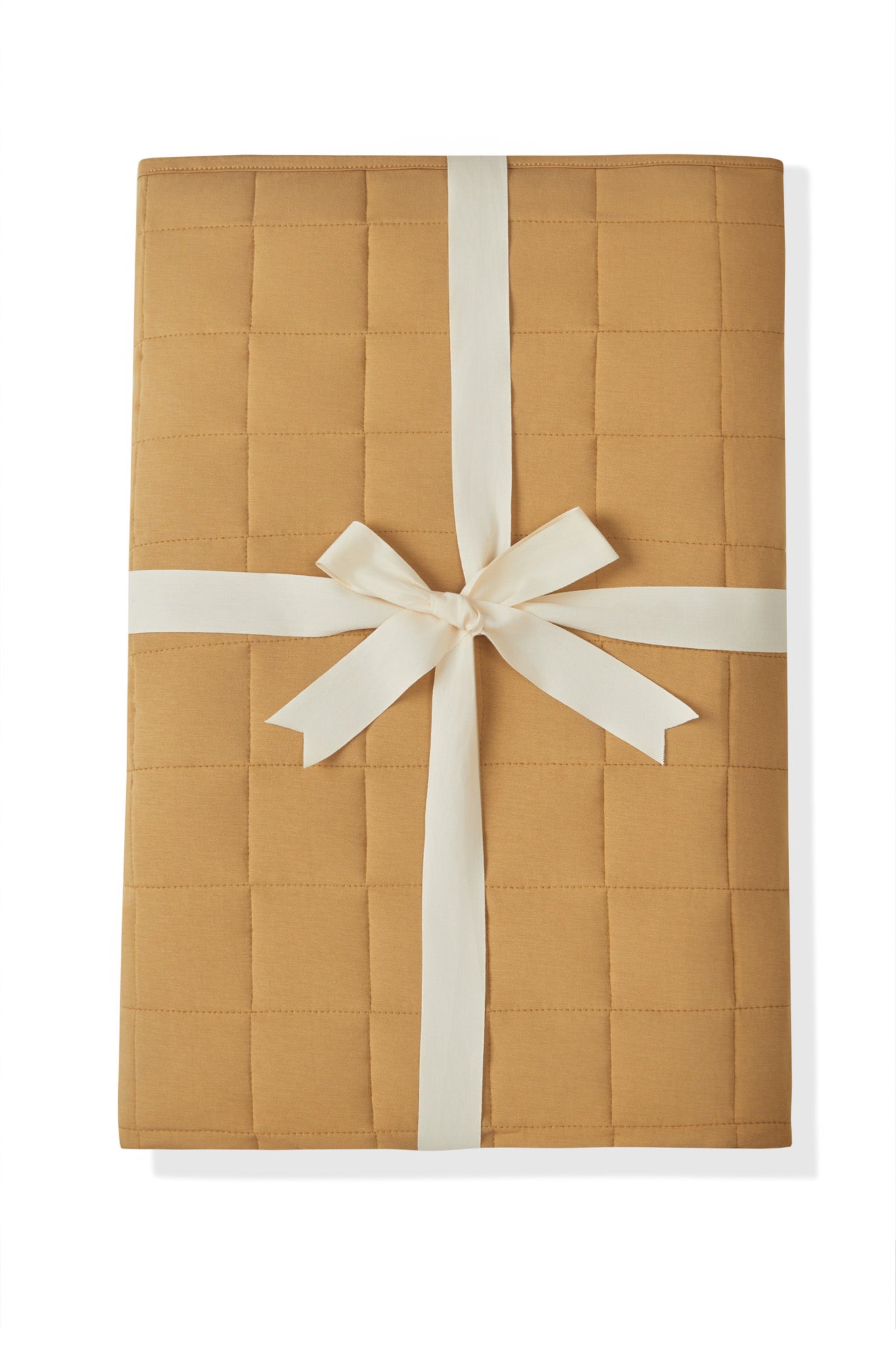 Adult Quilted Blanket in Ochre 2.5 wrapped in a ribbon bow on a white background