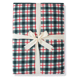 A folded gift box or package wrapped in a green, white, and red gingham plaid pattern, tied with a cream-colored satin ribbon and bow, on a white background.