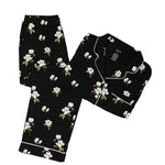 Black pajama set with white magnolia flower print on a white backdrop