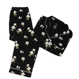 Black pajama set with white magnolia flower print on a white backdrop
