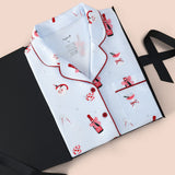 Long-Sleeved Women's Pajama Set in Merry and Bubbly print packed in a black box on a beige background