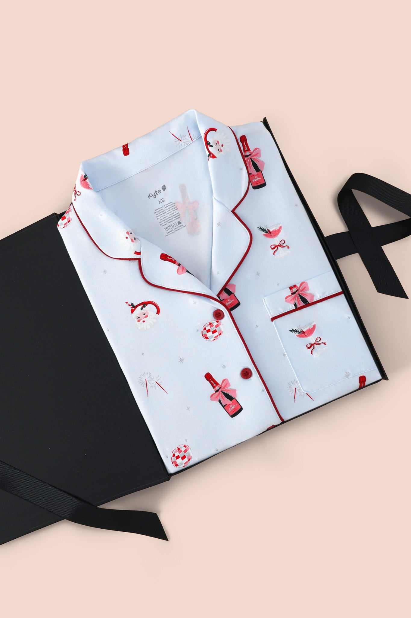 Long-Sleeved Women's Pajama Set in Merry and Bubbly print packed in a black box on a beige background