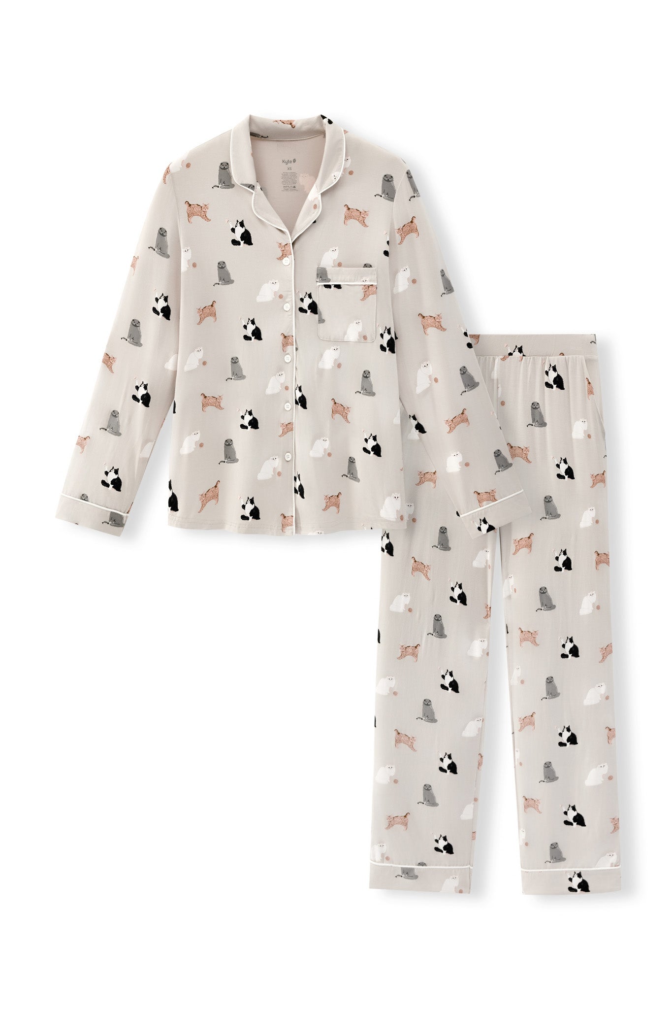A two-piece long-sleeve pajama set featuring a button-up top and matching pants in a light beige color, both printed with a repeating pattern of cats.