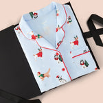 Blue Long-Sleeved Women's Pajama Set in Holiday Pups print packed in a box on a beige background