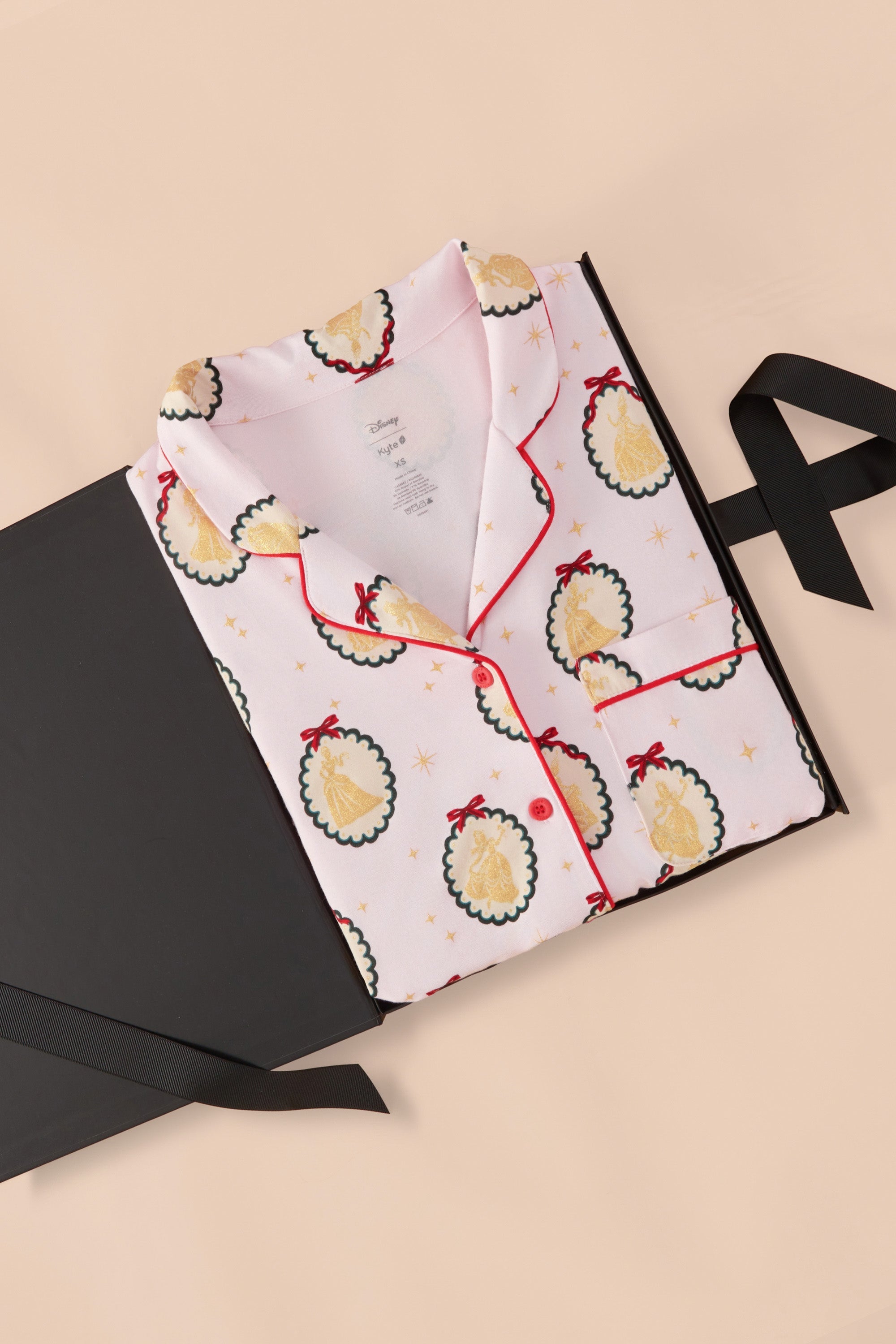 Long-Sleeved Women's Pajama Set in Princess Holiday Portraits print packed in a box on a beige background