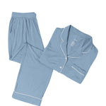 Slate blue pajama set with white piping on a white backdrop