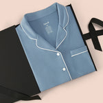 Long-Sleeved Women's Pajama Set in Slate with Cloud Trim packed in a box on a beige background