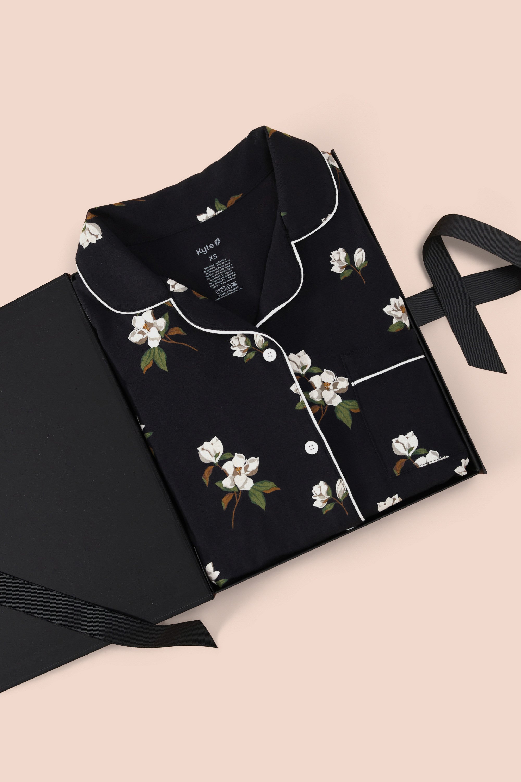 Women’s Short Sleeve Pajama Set in Big Midnight Magnolia packed in a box on a beige background