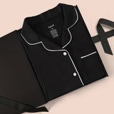 Women’s Short Sleeve Pajama Set in Midnight with Cloud Trim packed in a box on a beige background