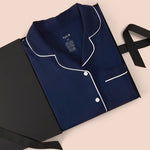 Women’s Short Sleeve Pajama Set in Navy with Cloud Trim packed in a box on a beige background