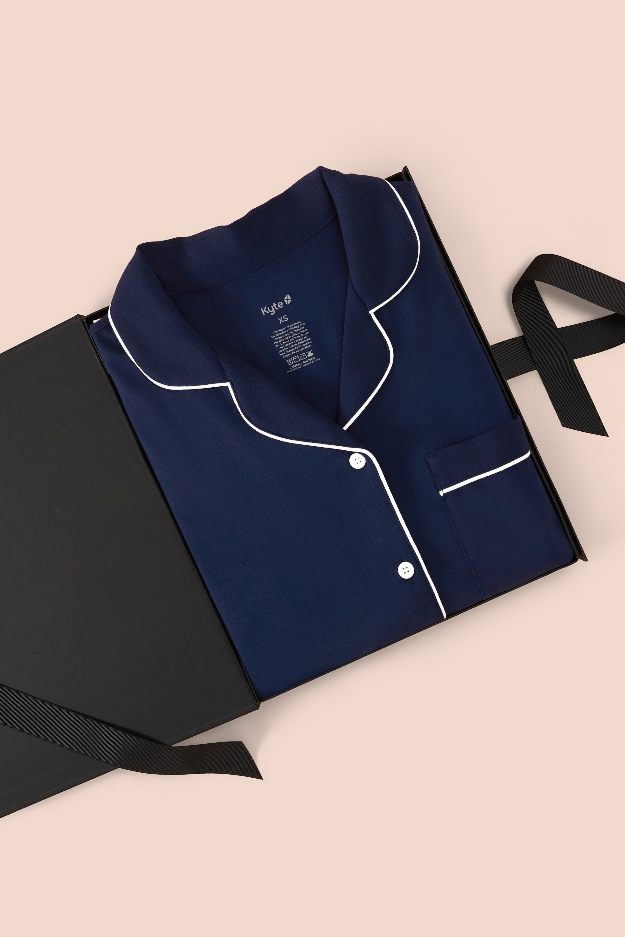 Women’s Short Sleeve Pajama Set in Navy with Cloud Trim packed in a box on a beige background