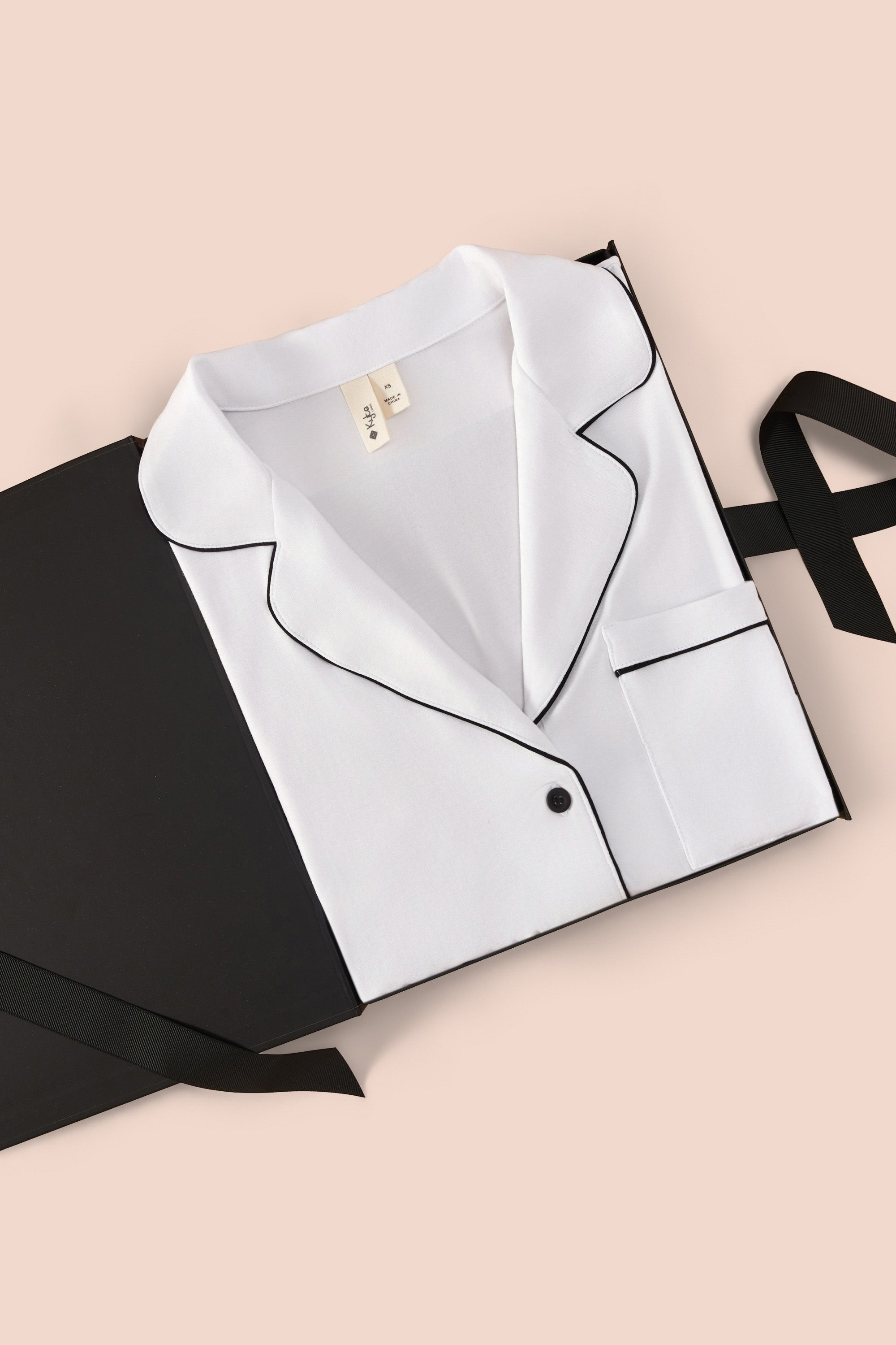 Women’s Short Sleeve Pajama Set in Snow with Midnight Trim packed in a box on a beige background