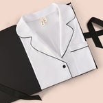 Women's Long Sleeve Pajama Set in Snow with Midnight Trim packed in a box on a beige background