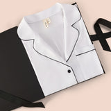 Women's Long Sleeve Pajama Set in Snow with Midnight Trim packed in a box on a beige background