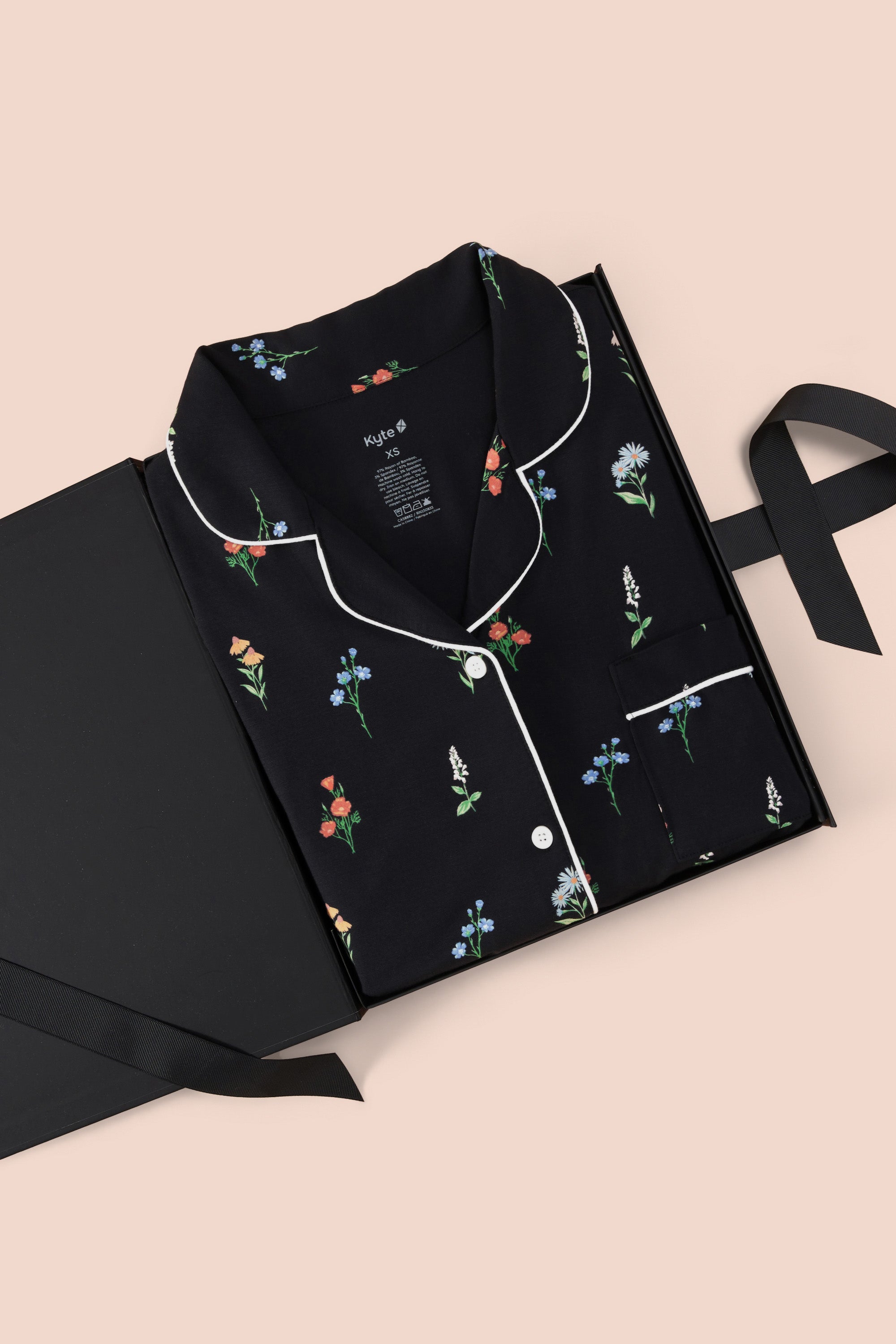 Women's Short Sleeve Pajama Set in Midnight Wildflower packed in a box on a beige background