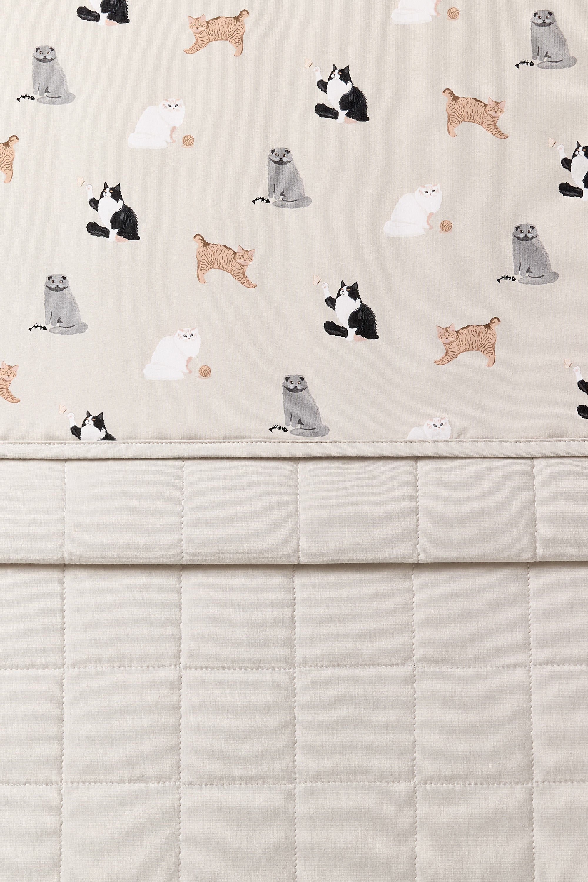 Close up of the Throw Blanket in Fluffy Cat 1.0 showing the quilted light beige backing and smooth top cat print layer