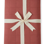 Youth Blanket in Ember 2.5 wrapped in a ribbon bow on a white background