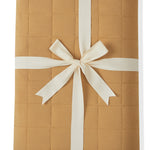 Youth Blanket in Ochre 2.5 wrapped in a ribbon bow on a white background