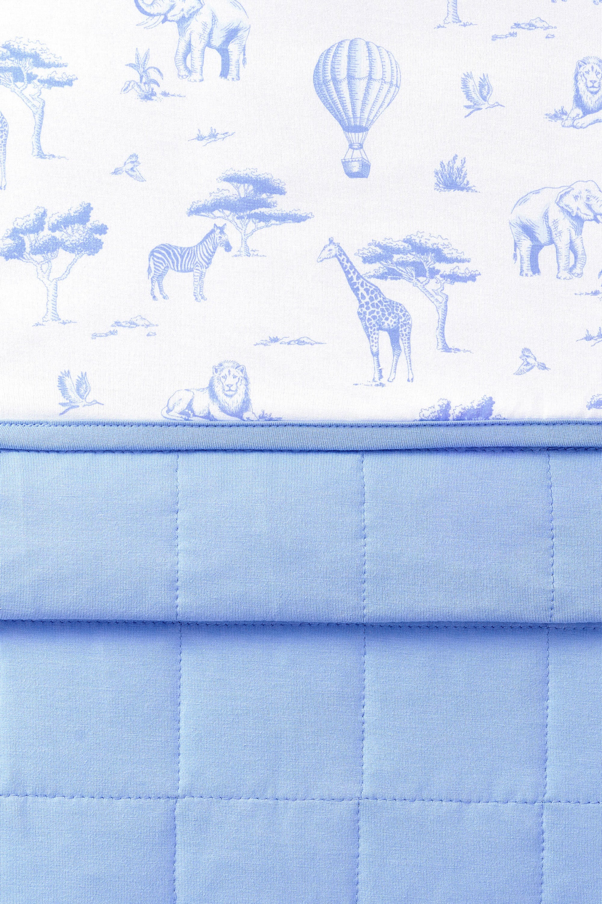 Close up of folded Bamboo Throw Blanket in Toile Safari 1.0 showcasing the printed and quilted side