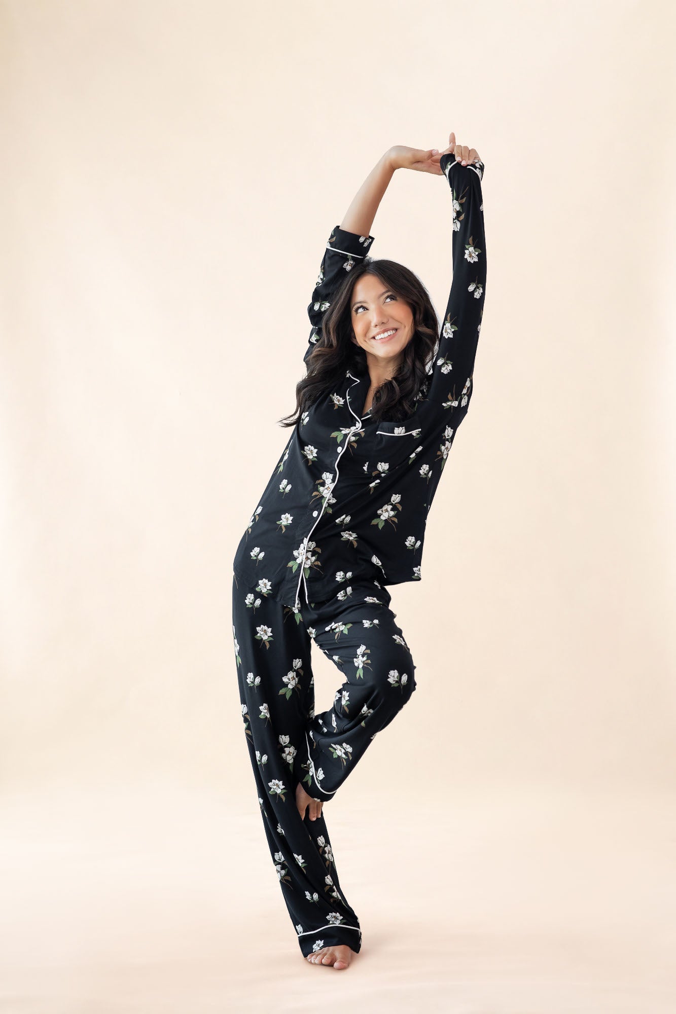 Woman wearing black floral pajamas on a beige background