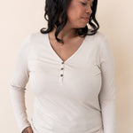 Woman modeling the Kyte Women's Long Sleeve Henley Tee in Bisque paired with light jeans