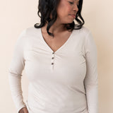 Woman modeling the Kyte Women's Long Sleeve Henley Tee in Bisque paired with light jeans
