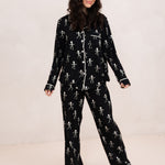Woman modeling the Bamboo Long-Sleeved Women's Pajama Set in Skeleton with feet shoulder width apart and looking to the side