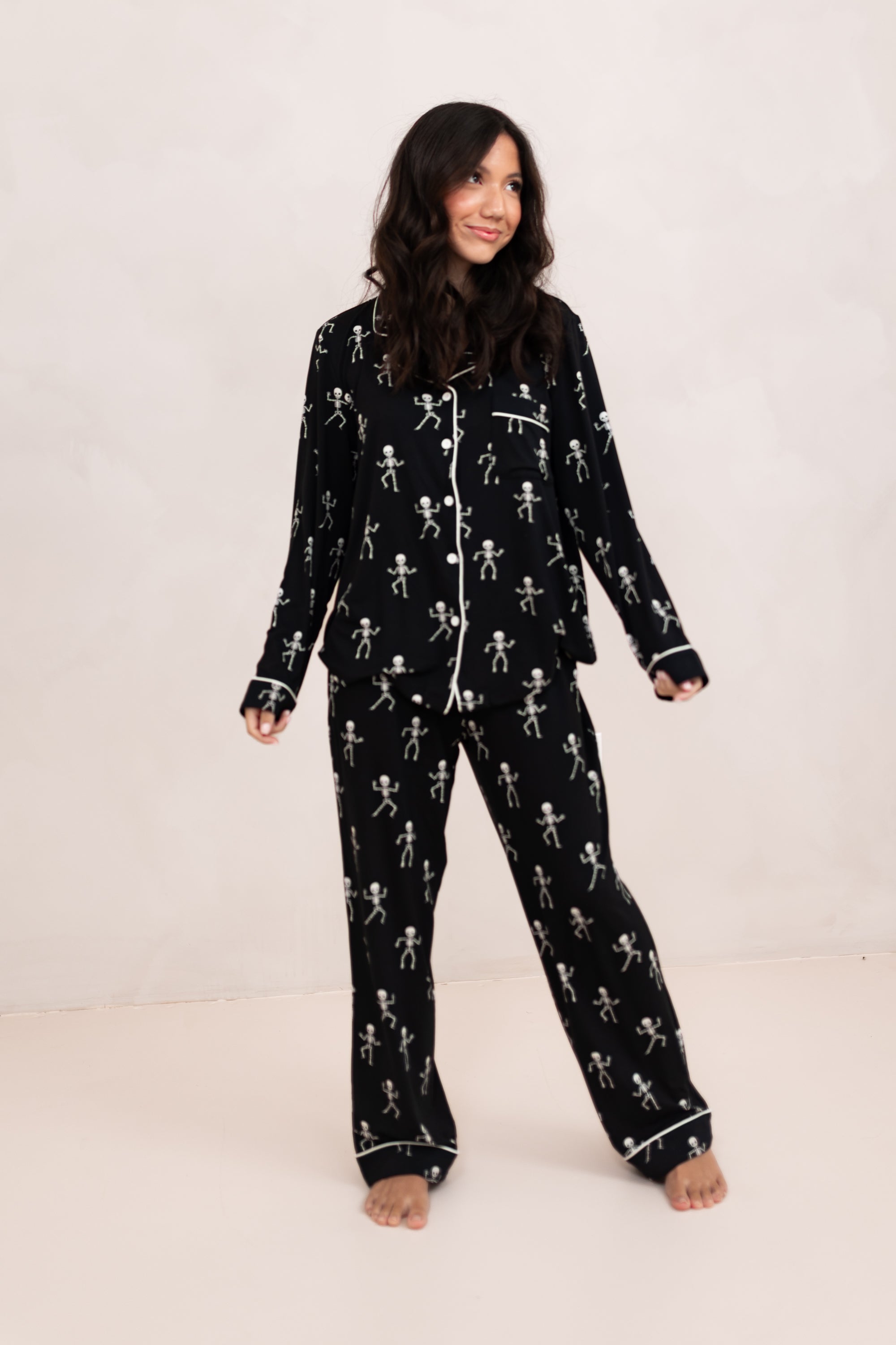Woman modeling the Bamboo Long-Sleeved Women's Pajama Set in Skeleton with feet shoulder width apart and looking to the side