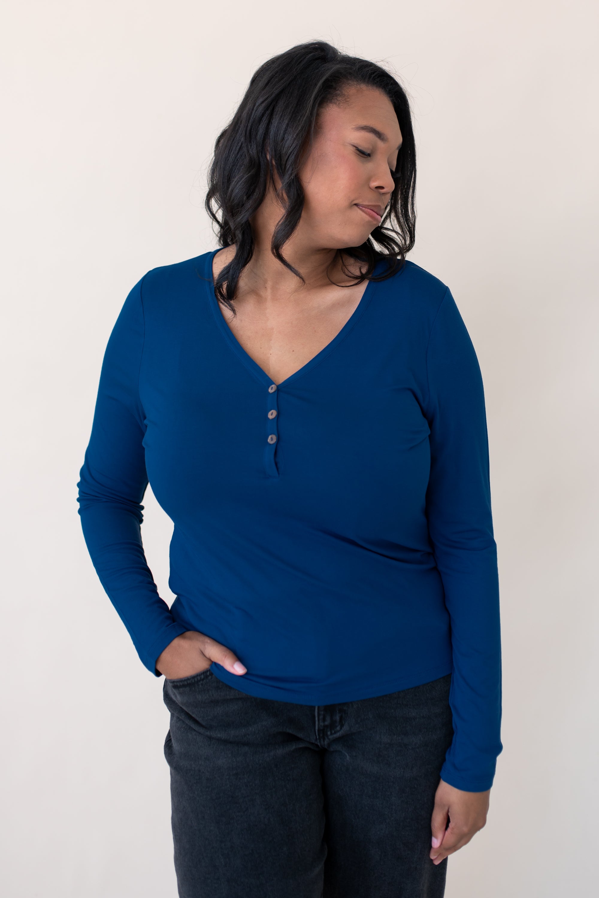 Woman looking to the side and modeling the Women's Long Sleeve Henley Tee in Tahoe