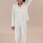 Woman wearing a bisque pajama set against a beige background