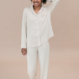 Woman wearing a bisque pajama set against a beige background