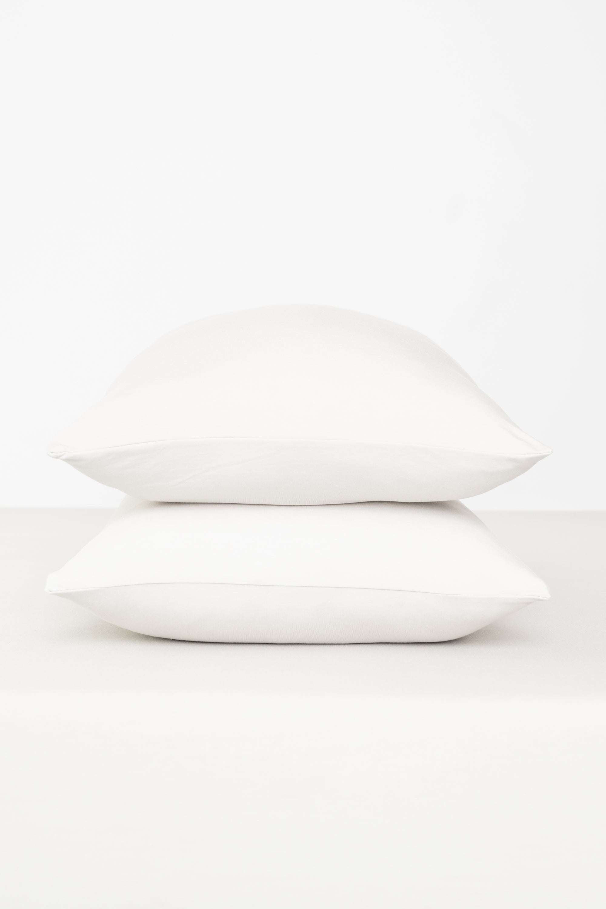 Fitted Sheet with Pillowcases in Cloud. Showing 2 pillows stacked on a sheet