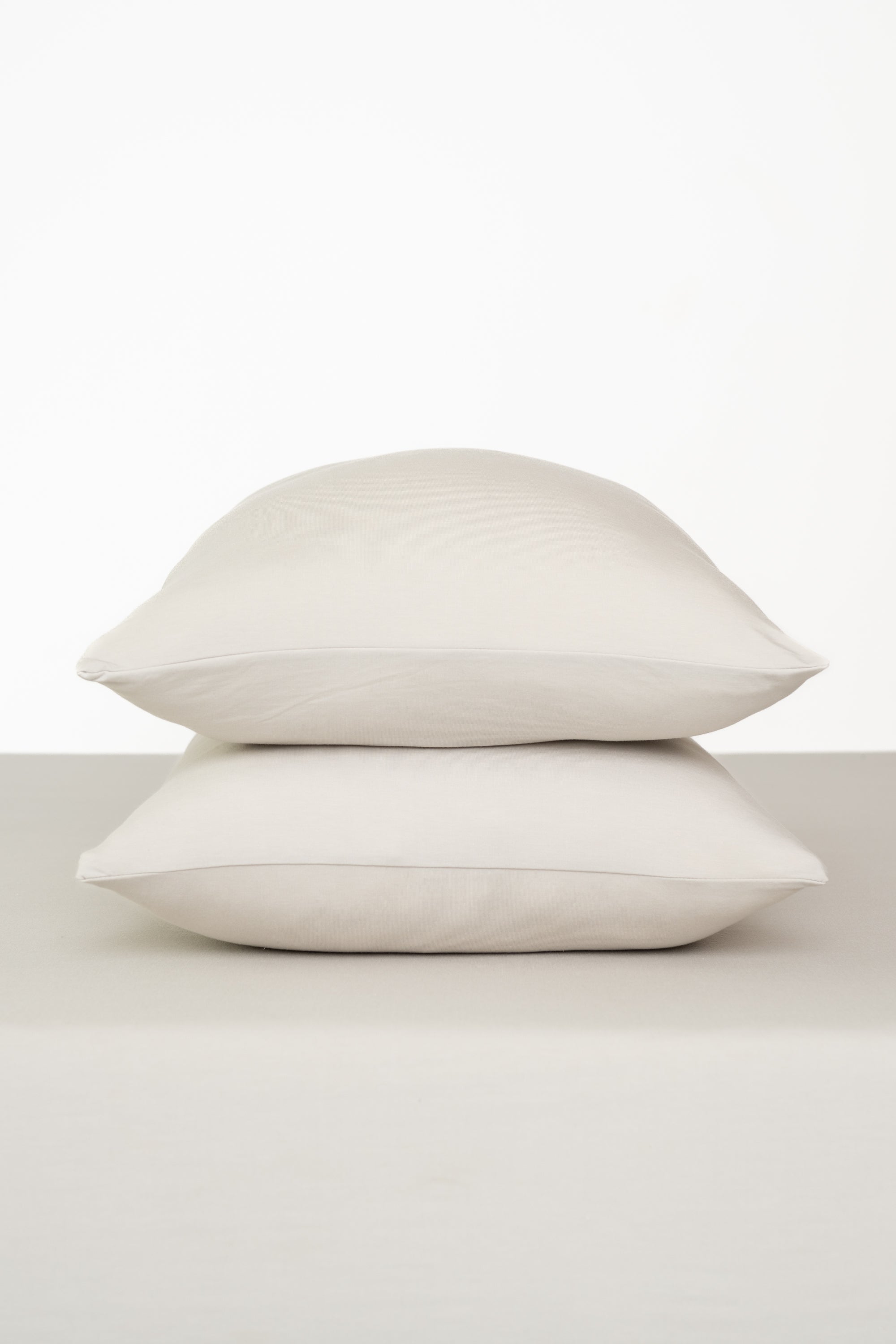Fitted Sheet with Pillowcases in Oat. Showing 2 pillows stacked on a sheet