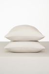 Fitted Sheet with Pillowcases in Oat. Showing 2 pillows stacked on a sheet