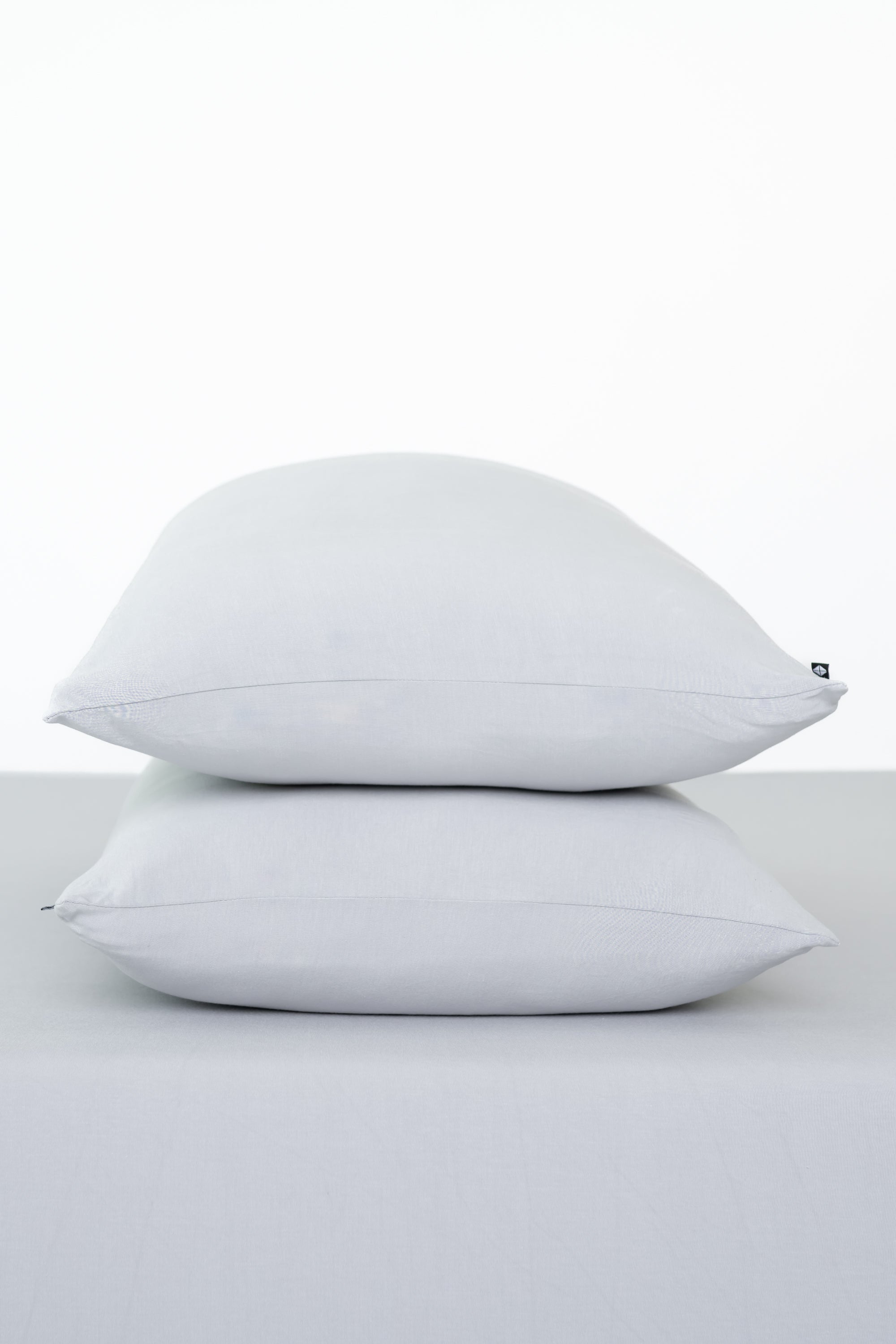 Fitted Sheet with Pillowcases in Storm. Showing 2 pillows stacked on a sheet