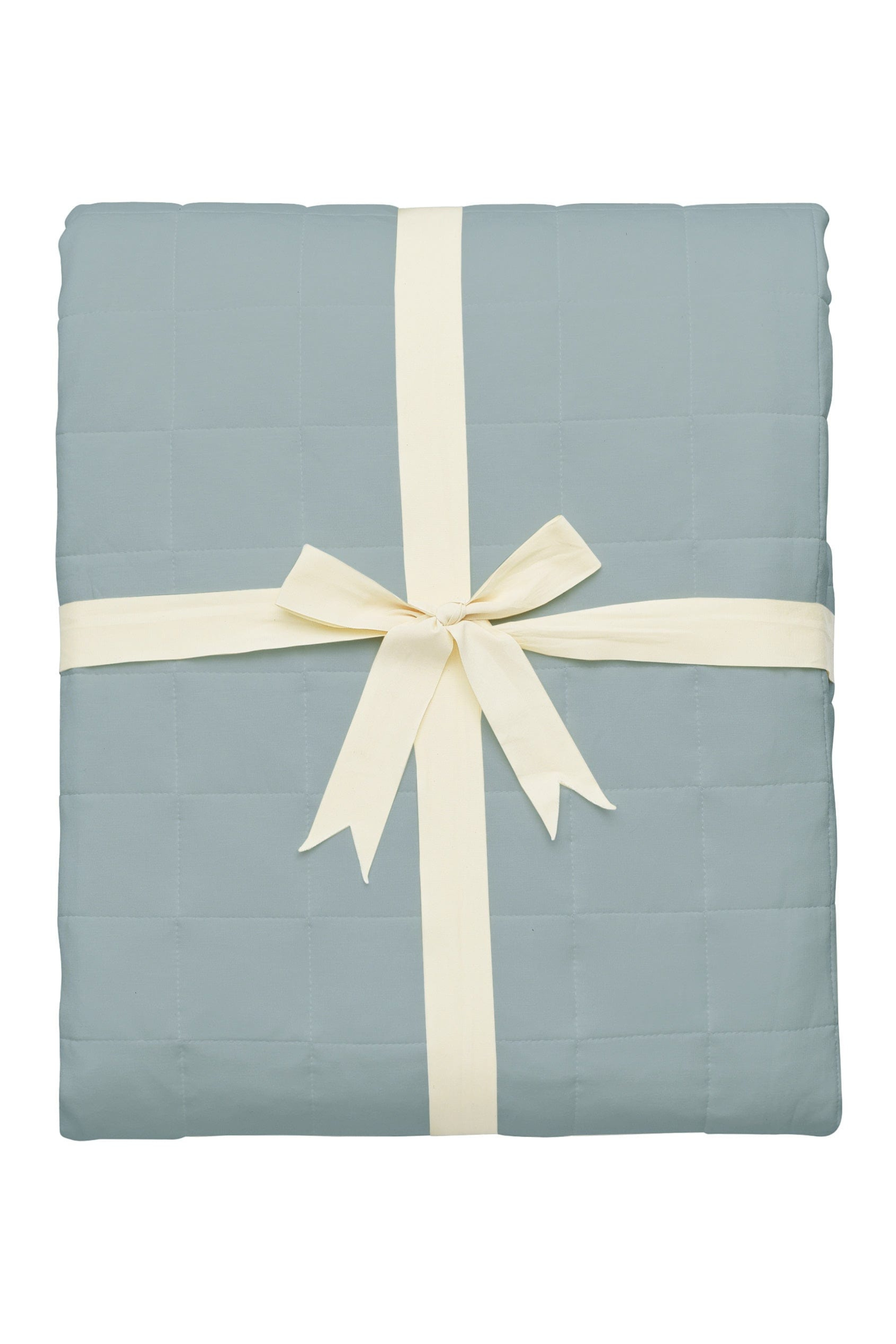 Light blue quilt with a white ribbon on a white background