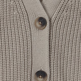 Close-up of a ribbed knit cardigan sweater in a light taupe-beige color, featuring two dark brown buttons on the front.