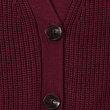 Close-up of a ribbed knit cardigan in deep burgundy with two dark buttons, showing the texture and neckline detail.