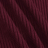 Close-up of a ribbed knit fabric in a deep burgundy or maroon color, showing the detailed texture and folds of the material.