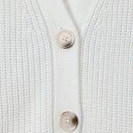 Close-up of a white ribbed knit cardigan with two beige buttons on a clean white background.