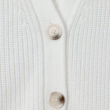 Close-up of a white ribbed knit cardigan with two beige buttons on a clean white background.