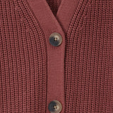 Close-up of a ribbed knit cardigan in a dusty rose or mauve pink color, featuring three dark gray buttons down the front center.