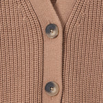 Close-up of a ribbed knit cardigan in a warm taupe-beige color, featuring three dark gray buttons down the front center.