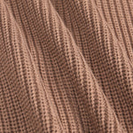 Close-up of a ribbed knit fabric in a warm taupe-brown color, showing the detailed texture and folds of the material.