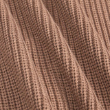 Close-up of a ribbed knit fabric in a warm taupe-brown color, showing the detailed texture and folds of the material.