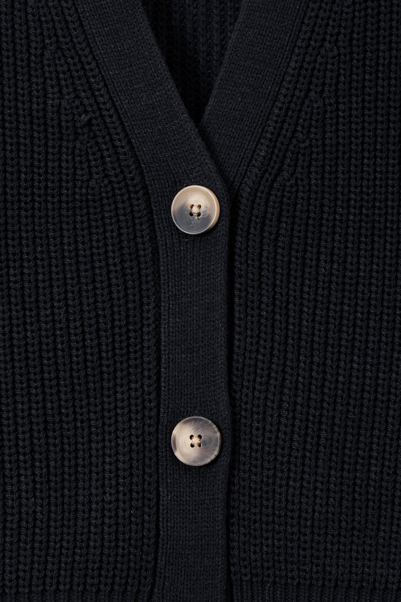 Close up of black knit cardigan with buttons