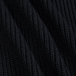 Close-up of a black ribbed knit fabric texture with soft diagonal folds.