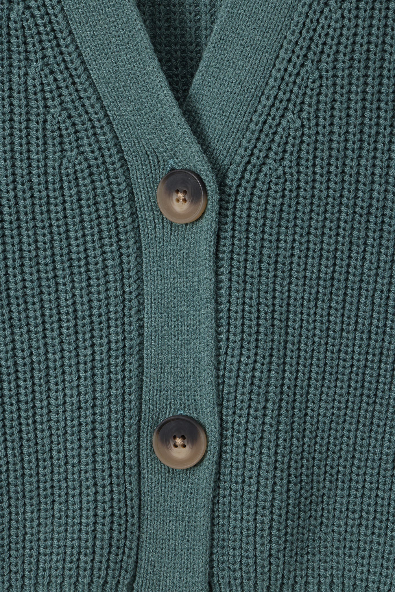 Close-up of a teal green ribbed knit cardigan sweater showing the button placket with two dark brown buttons.