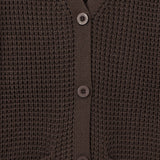 Close-up of a dark brown waffle-knit cardigan sweater showing the buttoned front and ribbed collar, cuffs, and hem.