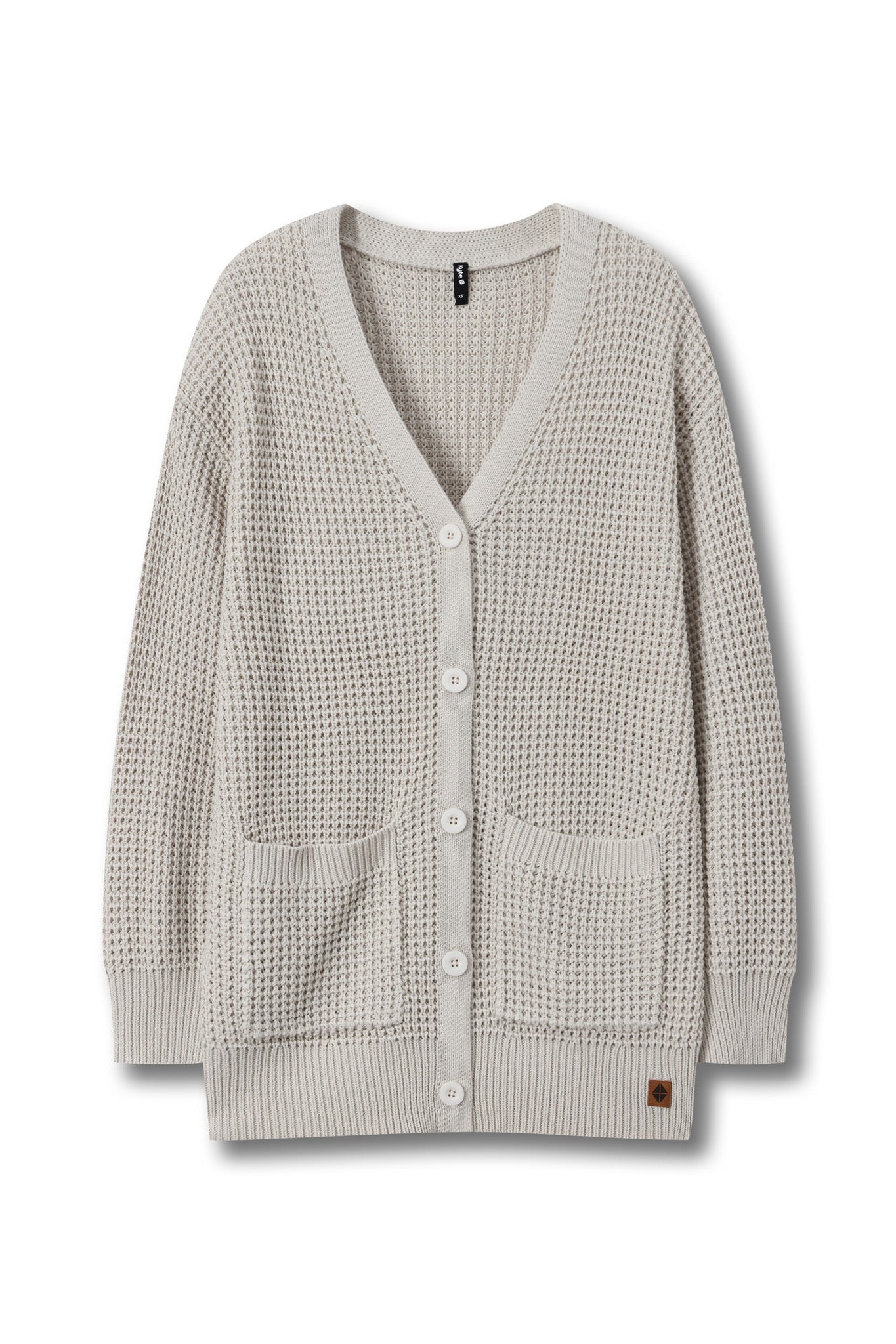 A light beige waffle-knit cardigan sweater with a V-neck, white buttons, and two front patch pockets, shown against a plain white background.